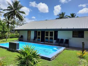 a house with a swimming pool in front of it at Haven Retreat in Pacific Harbour