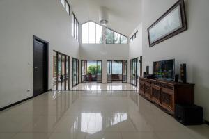 a large living room with white walls and windows at Barusen Hills By BHATARA in Gambung