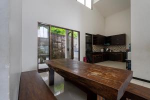 a kitchen with a wooden table in a room at Barusen Hills By BHATARA in Gambung
