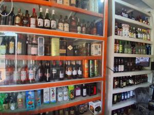 półka wypełniona mnóstwem butelek alkoholu w obiekcie Hotel Matashree w mieście Magdāl
