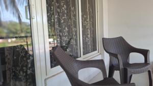 dwa krzesła ustawione na ganku obok okna w obiekcie Hotel Matashree w mieście Magdāl