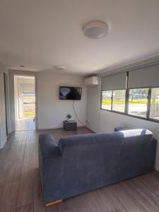 a living room with a blue couch and a tv at Pioneer Caravan Park in Dalby
