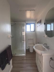 a white bathroom with a sink and a shower at Pioneer Caravan Park in Dalby +37 photos