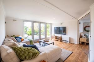 a living room with two couches and a tv at Aurora in Queenscliff