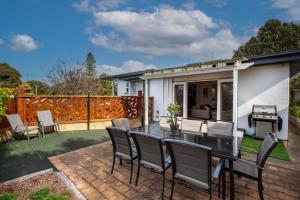 a patio with a dining table and chairs at Aurora in Queenscliff