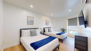 a bedroom with two beds and a flat screen tv at Ocean's Edge Luxury Rentals in Ocean City