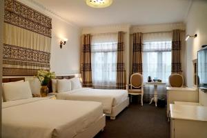 a hotel room with two beds and a table at Luxor Boutique Hotel in Hanoi +42 photos