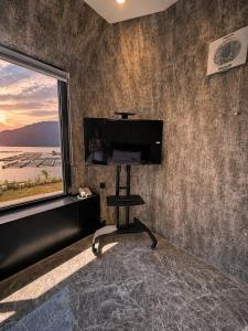 a living room with a flat screen tv on a wall at montevela glamping kintamani in Kubupenlokan