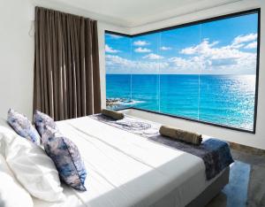 a bedroom with a large window overlooking the ocean at condostmaarten by the sea -Adults Only- in Koolbaai +48 photos