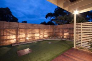 a backyard with a fence and aificialificialificialificialificialificialificialificial yard at Amaroo by the beach in Queenscliff