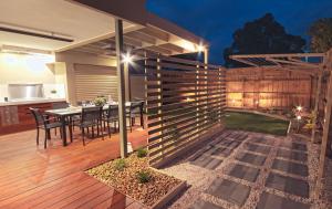 a patio with a table and chairs on a deck at Amaroo by the beach in Queenscliff
