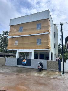 a building with a scooter parked in front of it at Silver waves beach stay in Mūlki +4 photos
