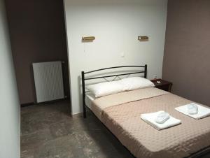 a bedroom with a bed with two towels on it at Parishouse by zarkco in Porto Rafti