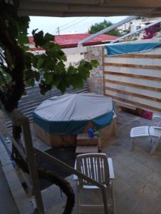 a tent and a chair on a patio at Parishouse by zarkco in Porto Rafti