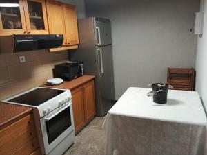 a small kitchen with a white stove and refrigerator at Parishouse by zarkco in Porto Rafti
