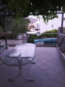 a glass table sitting on top of a patio at Parishouse by zarkco in Porto Rafti