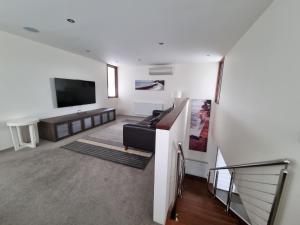 a living room with a couch and a flat screen tv at Beach Haven in Point Lonsdale