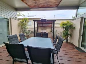 a table and chairs sitting on a deck with a table and chairsktop at Beach Haven in Point Lonsdale