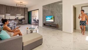 a man and a woman sitting in a living room at condostmaarten by the sea -Adults Only- in Koolbaai
