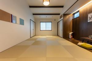 an empty hallway with a large tile floor and a window at Irodori Hotel AKANE in Fukuoka