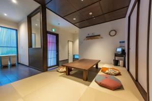 a living room with a table and a couch at Irodori Hotel AKANE in Fukuoka