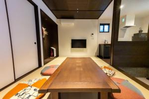 a living room with a wooden table and a tv at Irodori Hotel AKANE in Fukuoka