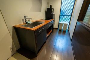a kitchen with a sink and a counter top at Irodori Hotel AKANE in Fukuoka +8 photos