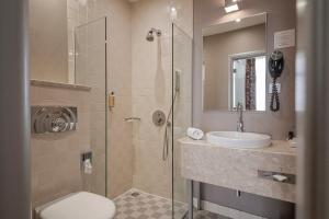 a bathroom with a shower and a toilet and a sink at Opera Hotel in Riga