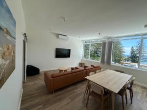 a living room with a couch and a table at Seabreeze Beach Hotel in South West Rocks