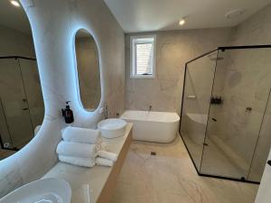 a bathroom with a tub and a sink and a shower at Seabreeze Beach Hotel in South West Rocks +39 photos