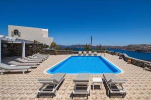 a villa with a swimming pool and lounge chairs at Sigal Villa in Akrotiri