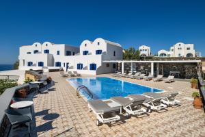 a pool with chaise lounge chairs and a resort at Sigal Villa in Akrotiri