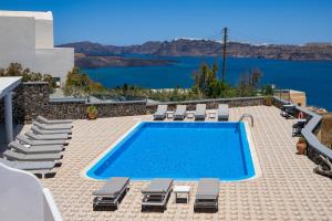 a swimming pool with chaise lounge chairs and a pool at Sigal Villa in Akrotiri
