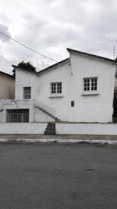 a white house with two windows and a street at Suíte cine centro in Garanhuns