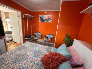 a bedroom with orange walls and a bed and a mirror at Cozy Curtin Cottage in Lyons