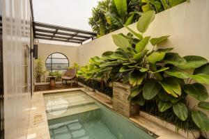 a swimming pool in a building with plants at Sunsetfalls Gardens and Resort in Magelang