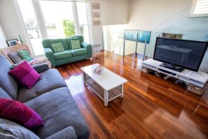 a living room with a couch and a flat screen tv at Bella Casa in Queenscliff