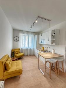 a kitchen with a table and a yellow couch at HOME PERLa in San Bartolomeo al Mare