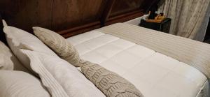 a white bed with a wooden headboard and pillows at Chalé Selá - Recanto 23 - Espaço Inteiro - Entre Angra e Paraty in Angra dos Reis +5 photos