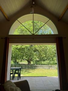 an arched window in a living room with a table at Au Bas Chalonge in Ligné