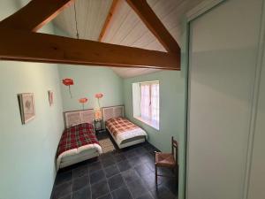 two beds in a room with a roof at Au Bas Chalonge in Ligné