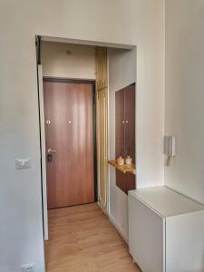 an empty hallway with a wooden door in a room at HOME PERLa in San Bartolomeo al Mare
