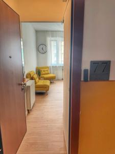 a hallway with a living room with a couch and a clock at HOME PERLa in San Bartolomeo al Mare