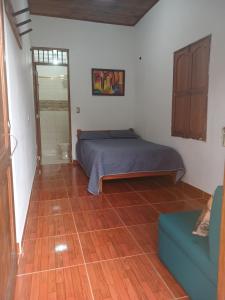 a bedroom with a bed and a couch in a room at La Escondida in Jardin