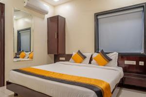 a bedroom with a large bed and two mirrors at Itsy Hotels M in Vijayawāda +25 photos