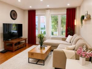 a living room with a couch and a tv at Vita House - Minutes to Rogers Stadium - Walk or Transit - Near VELD Downsview and Yorkdale in Toronto