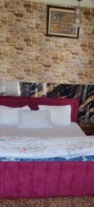 a bed in a room with a brick wall at Minnat Home Stay in Srinagar