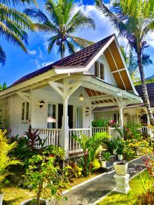 a house with a porch and palm trees at Jalana Palm Villa in Tabanan