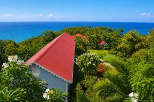 a house with a red roof and the ocean in the background at Mount Edgecombe Boutique Hotel in Maran