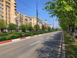 an empty street in a city with tall buildings at Adrian Home Libra in Ploieşti
